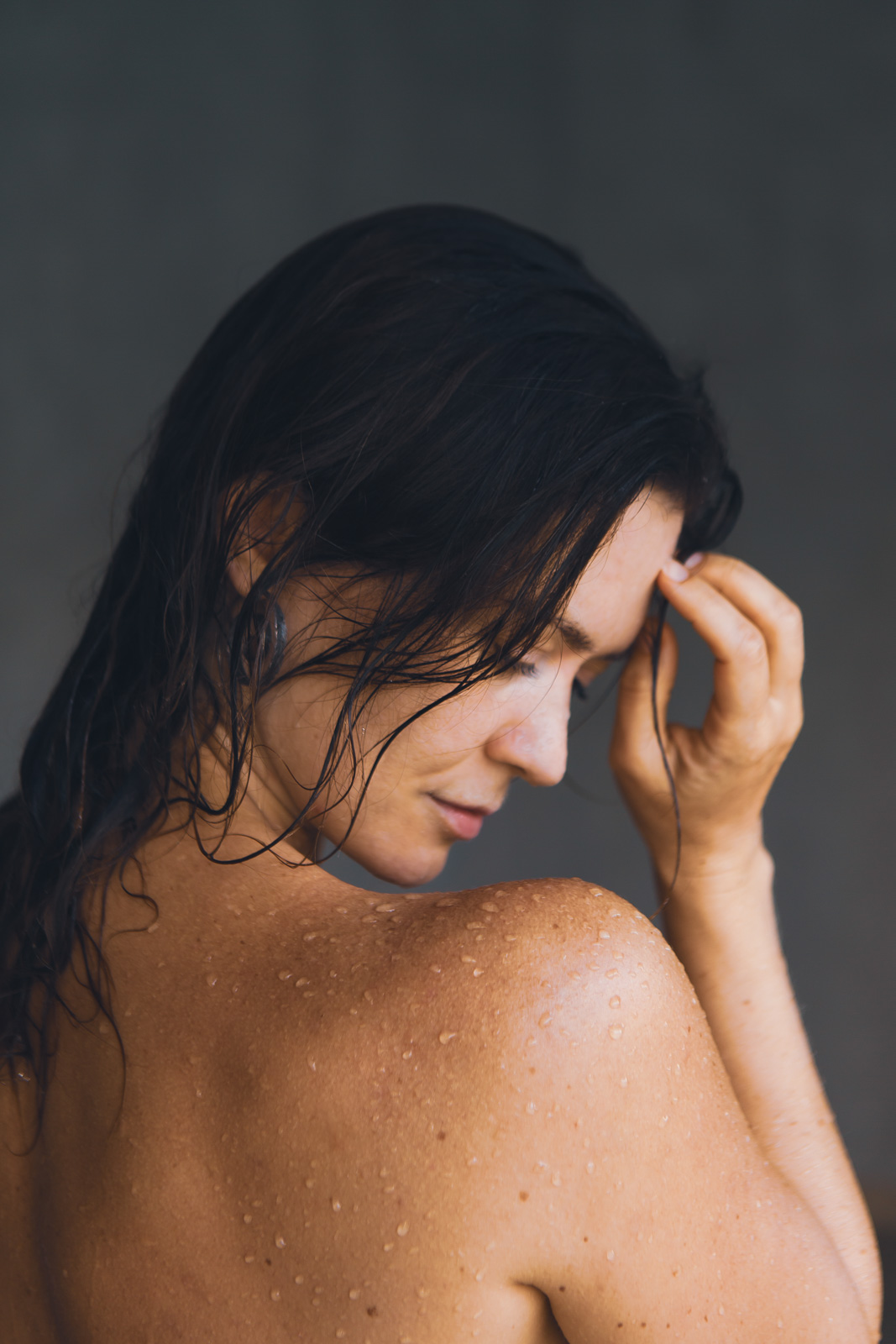 Detail ženského těla s kapkami vody